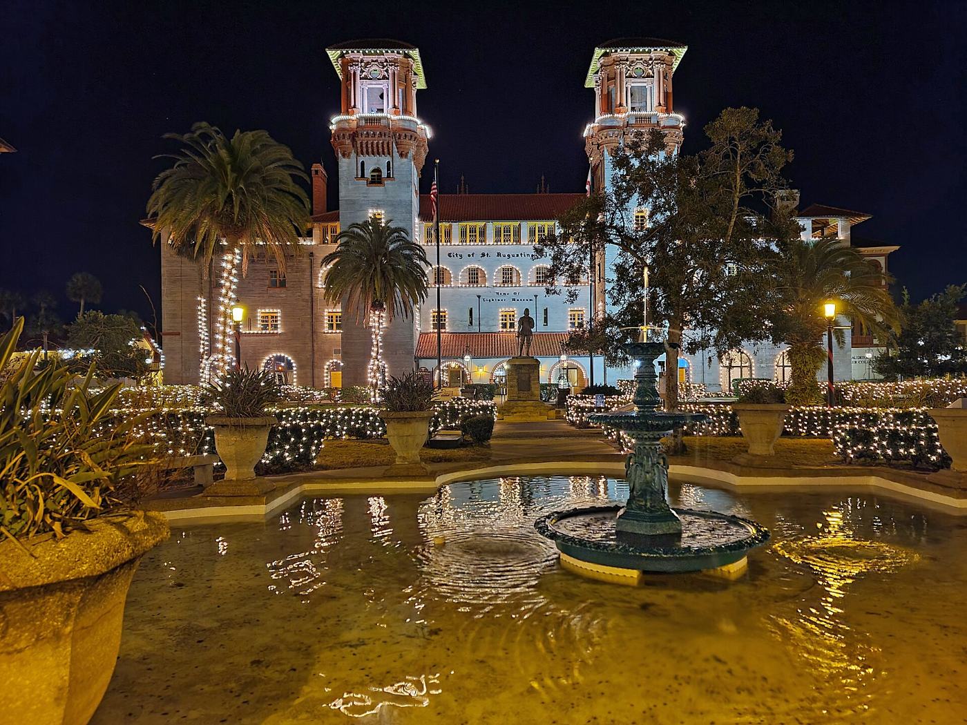 The Lightner Museum courtyard glowing with white holiday lights at night