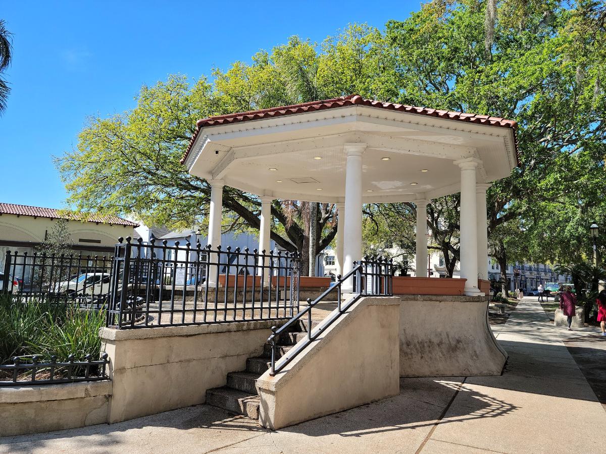 White gazebo in the Plaza de la Constitución under oak trees